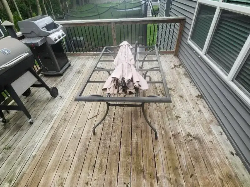 Same deck boards grey and weathered before washing